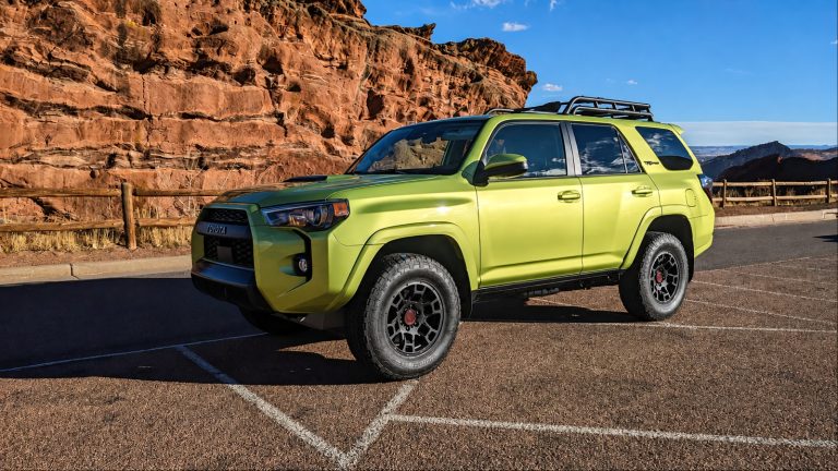 Lime-green Toyota 4Runner parked beside a rugged canyon landscape