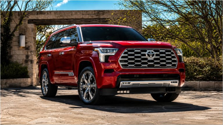 red Toyota Sequoia SUV parked outside a stone building