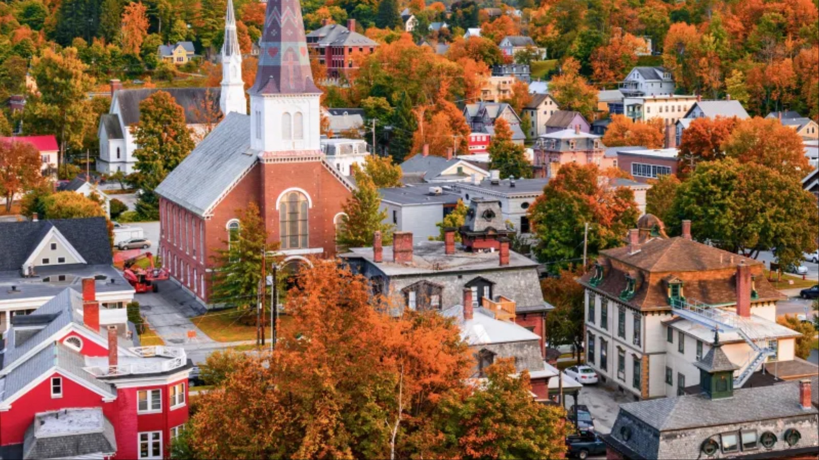 Aerial view of a historic town surrounded by vibrant autumn foliage