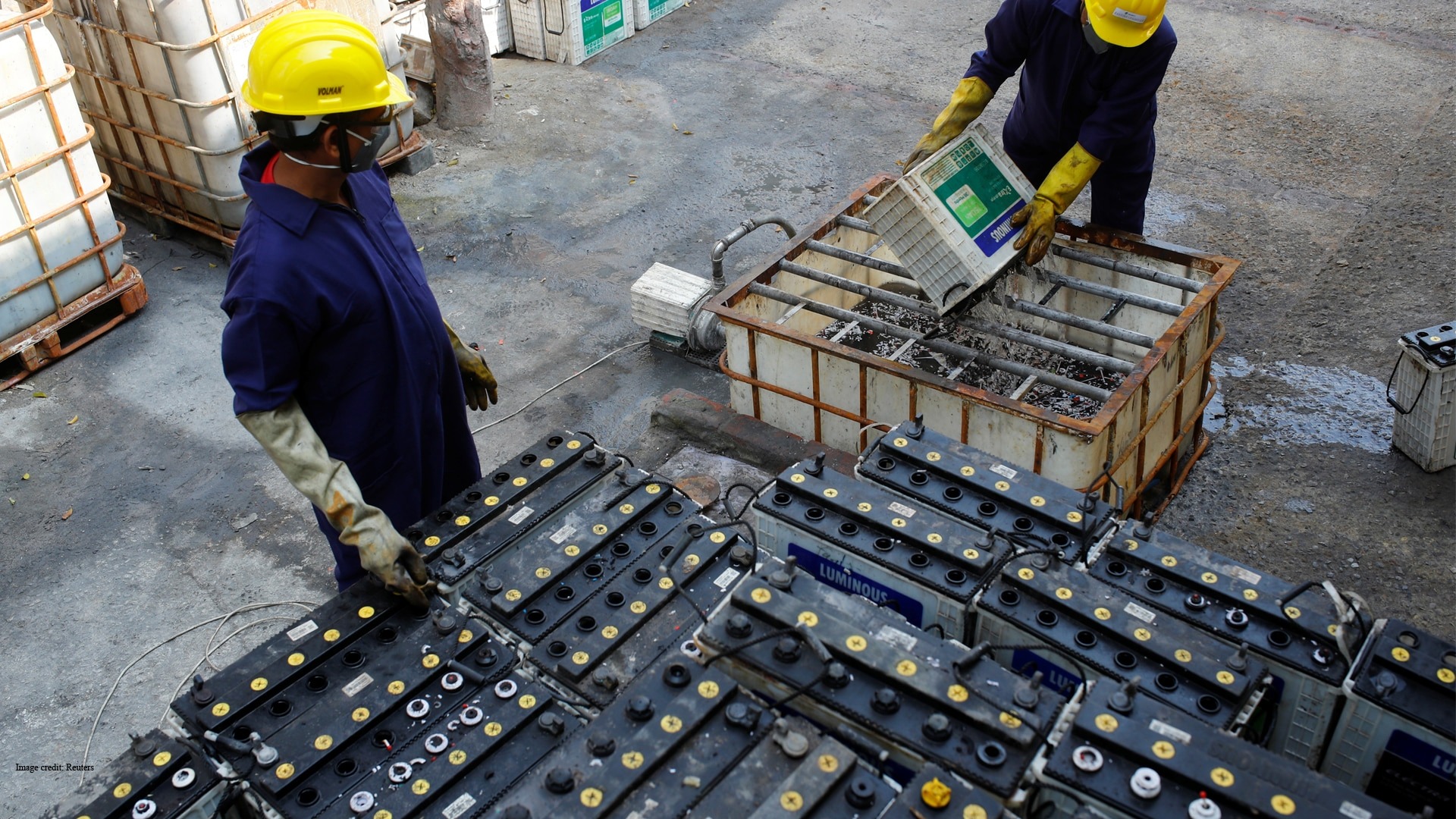 Workers dismantling used lead-acid batteries