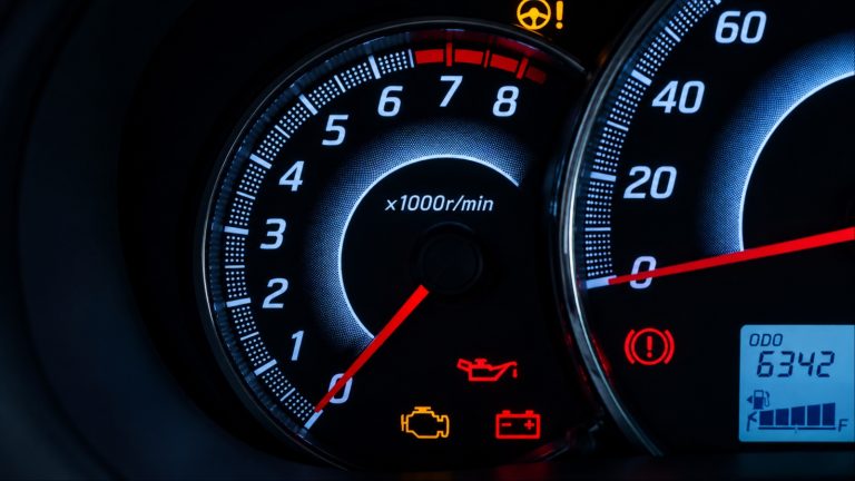 A car dashboard displays multiple warning lights, signaling potential mechanical or electrical problems