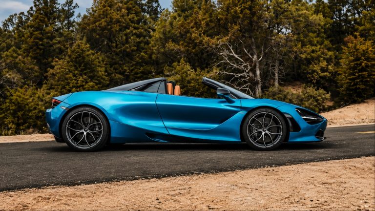 Blue McLaren convertible sports car parked on scenic mountain road