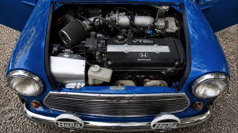 A detailed blue vintage Honda engine bay showcasing a DOHC VTEC engine and classic styling