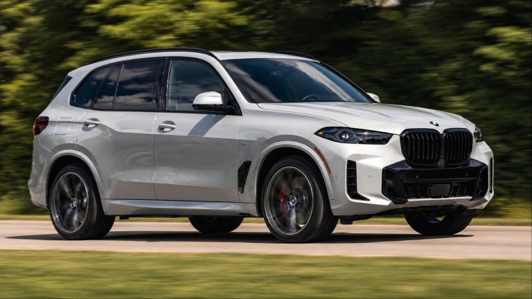 BMW X5 driving on a scenic road, showcasing its bold design and dynamic stance