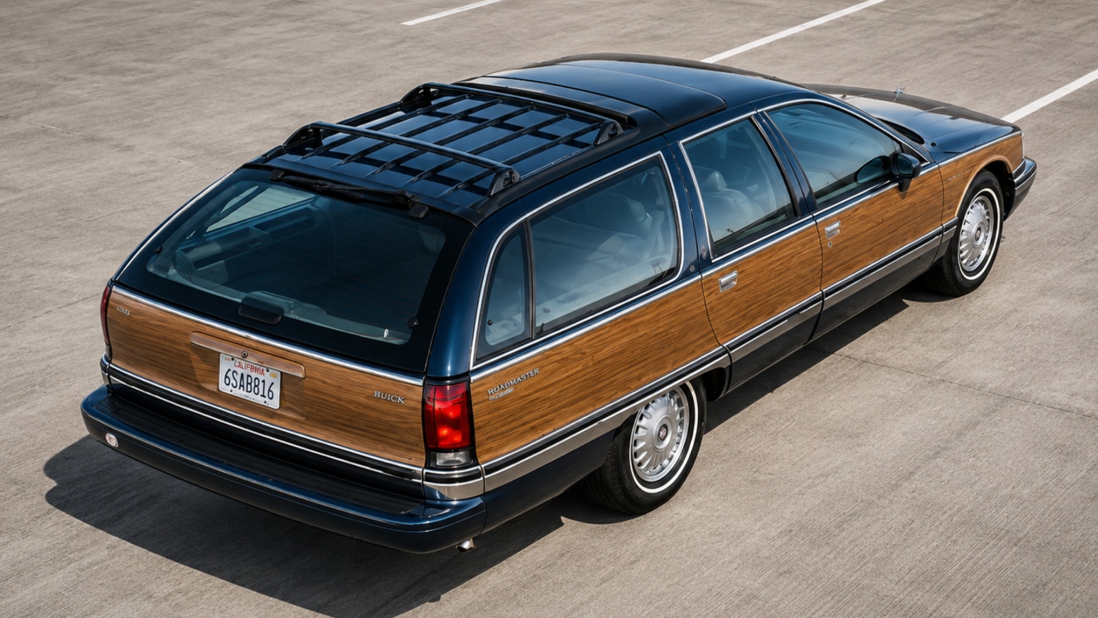 dark blue Buick Roadmaster station wagon with wood-grain side paneling parked on concrete