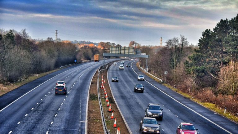 Busy divided highway carrying cars and trucks through a wooded landscape