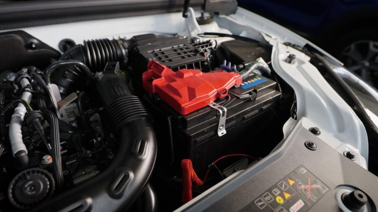 Car battery and engine components are visible under the vehicle’s hood