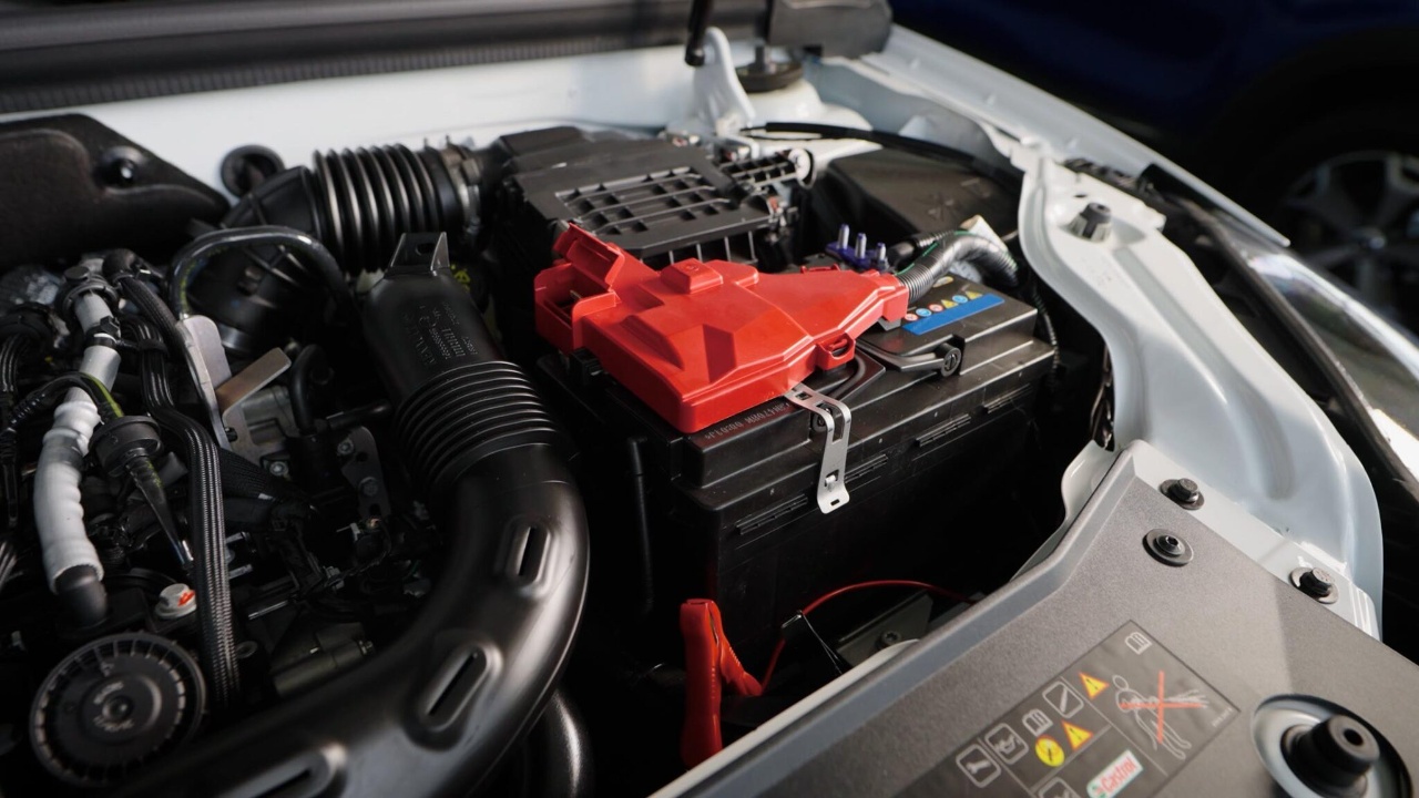 Car battery and engine components are visible under the vehicle’s hood