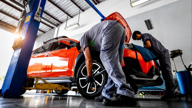Skilled mechanics working together inside a modern car repair shop