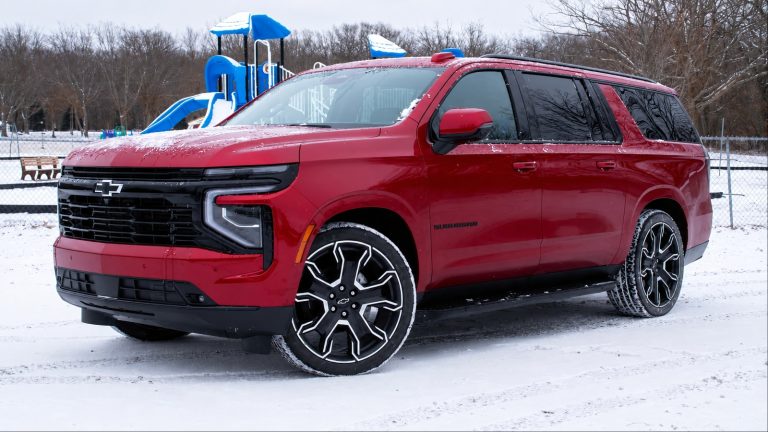 Chevrolet Suburban parked in a snowy park with a playground in the background
