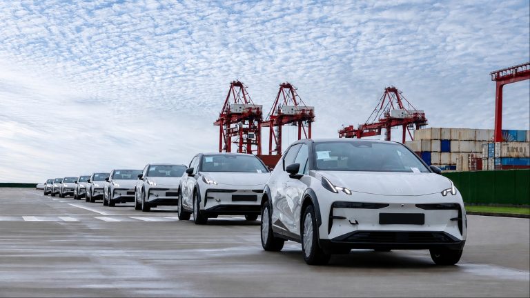 Chinese electric cars lined up at a port, highlighting rapid EV manufacturing and exports