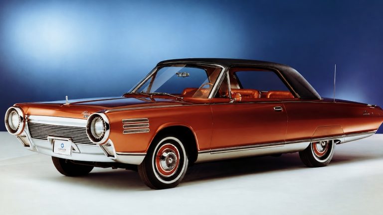 vintage bronze Chrysler Turbine car parked against a sleek gradient blue studio background