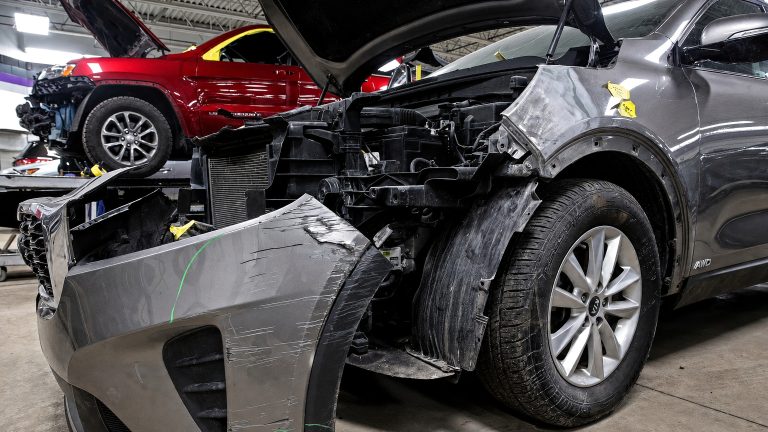 Dark gray Kia SUV with significant front-end damage