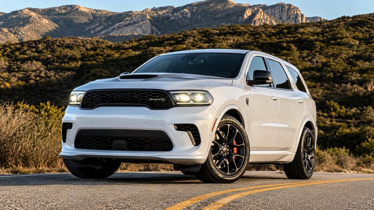 Dodge Durango parked on a scenic mountain road with rugged peaks behind