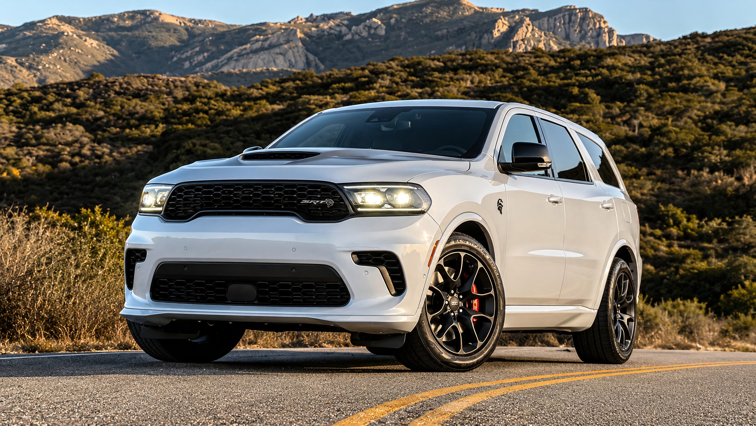 Dodge Durango parked on a scenic mountain road with rugged peaks behind