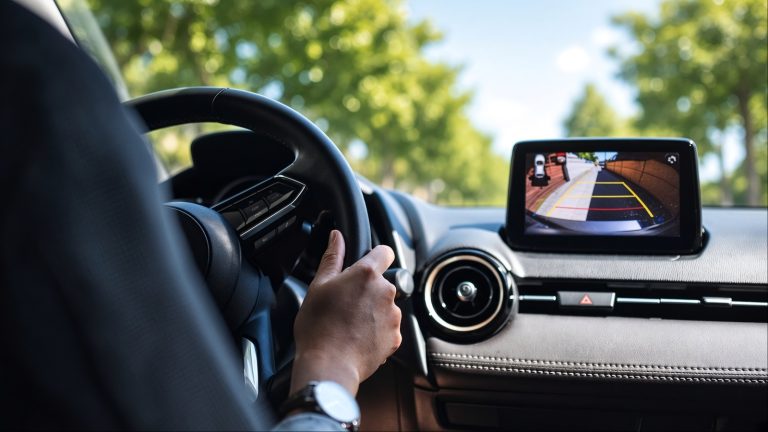 Driver uses a dashboard navigation screen while traveling on the road