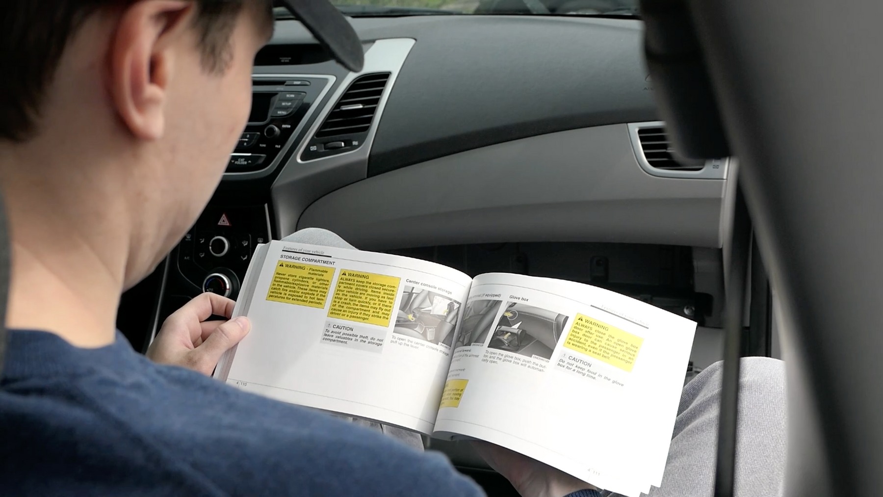Driver reading a vehicle owner's manual