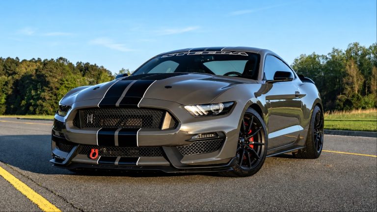 Ford Mustang Shelby GT350 parked on a road, featuring aggressive styling, racing stripes, and performance-focused details