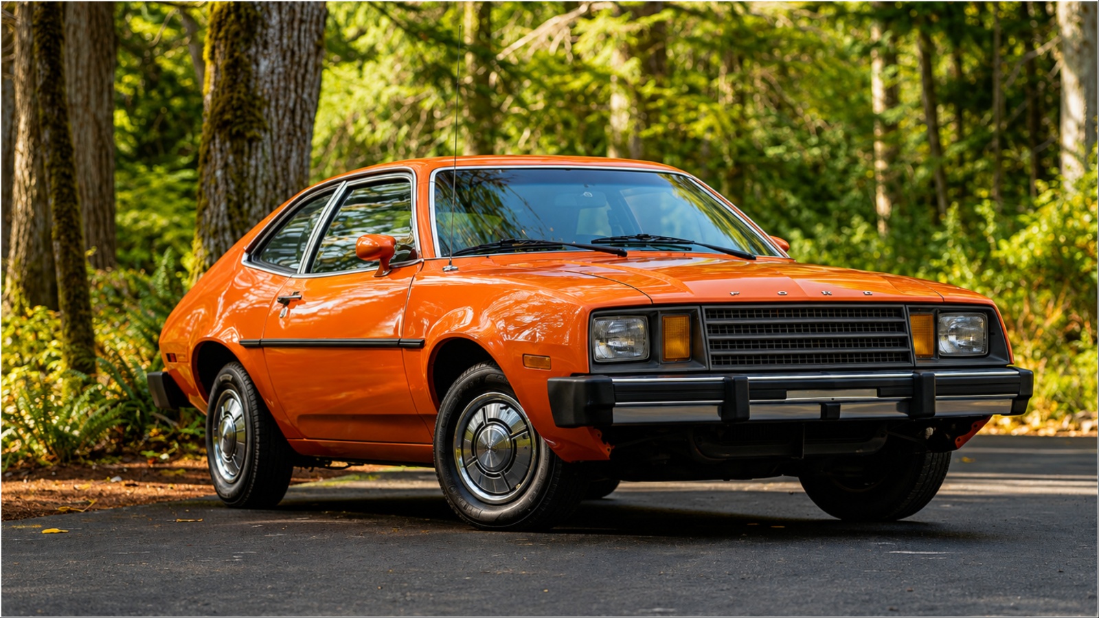 Orange late-1970s Ford Pinto hatchback parked on forest driveway