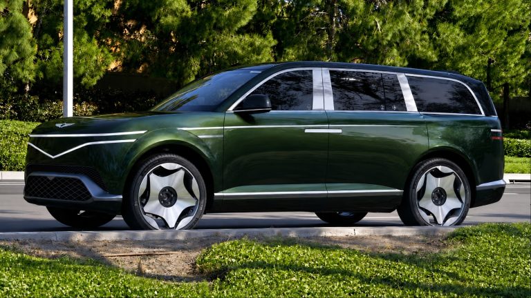 Genesis GV90 parked beside a landscaped road, showcasing its sleek luxury SUV design