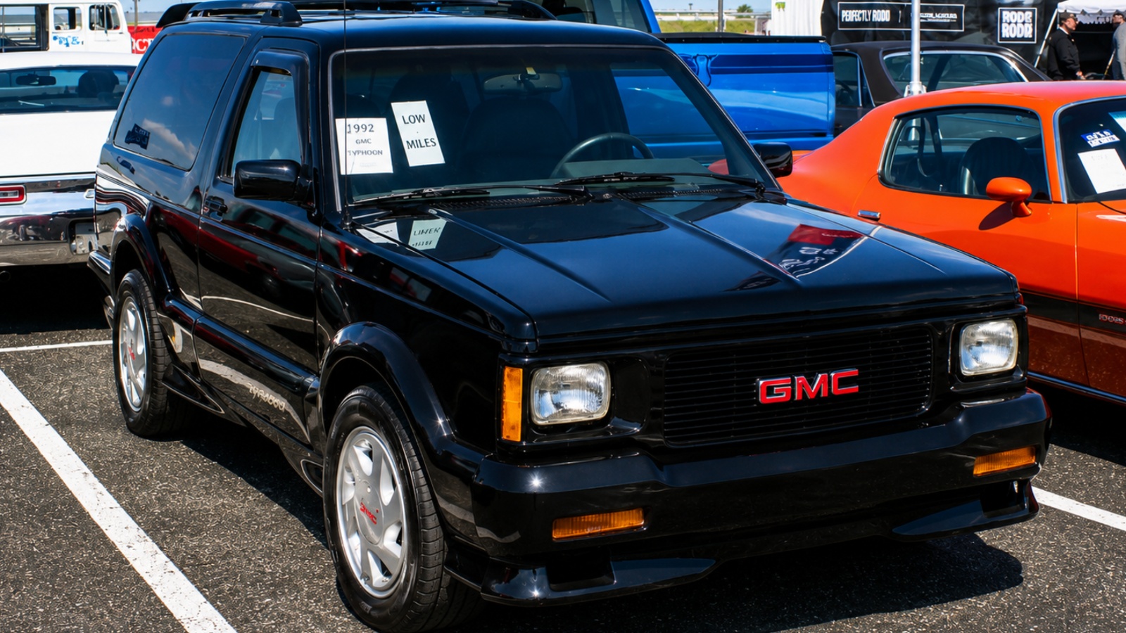 shiny black 1992 GMC Typhoon SUV parked at an outdoor car show