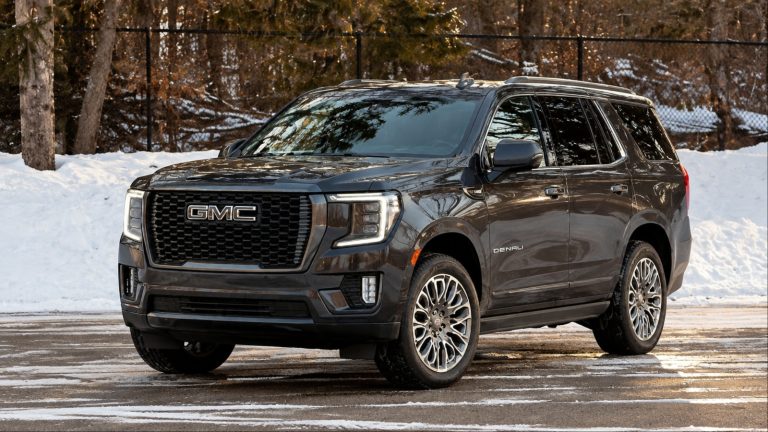 GMC Yukon Denali parked on a snowy road surrounded by winter scenery