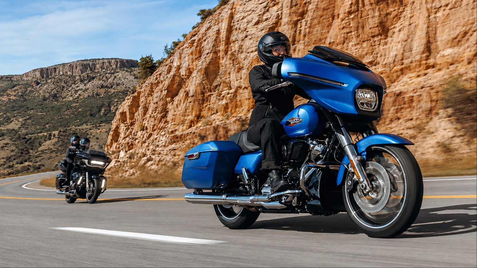 Harley-Davidson Street Glide touring motorcycle riding through a scenic mountain road
