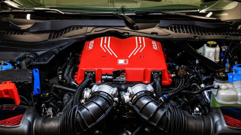 High-performance engine bay featuring a prominent red engine cover and twin intake systems