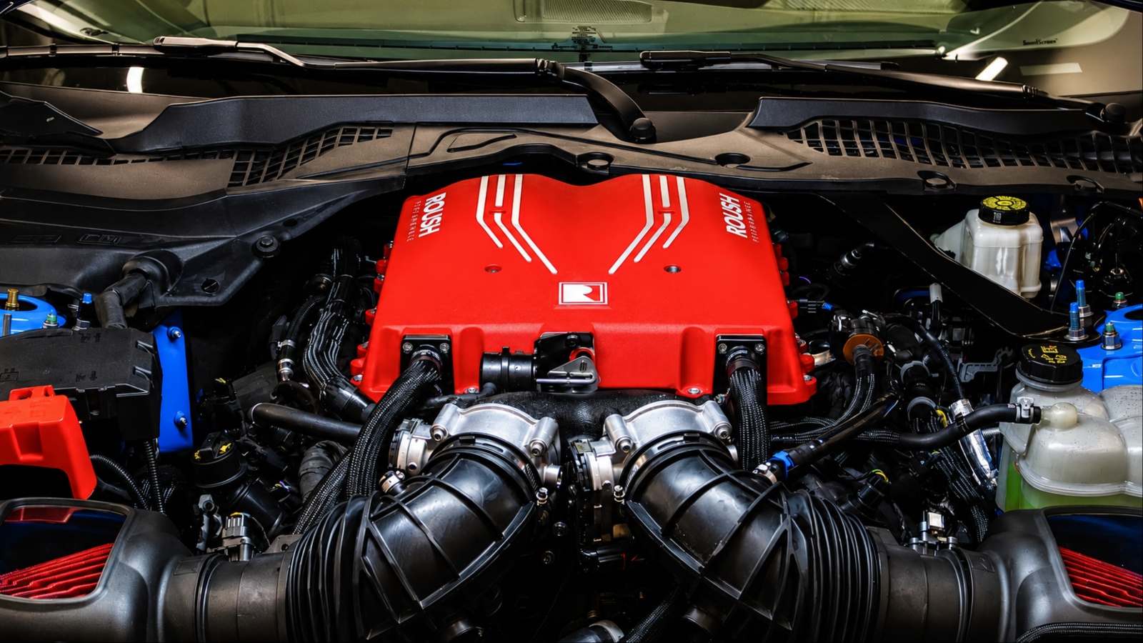High-performance engine bay featuring a prominent red engine cover and twin intake systems