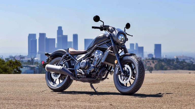 Honda Rebel 500 motorcycle overlooking the Los Angeles skyline under a clear blue sky