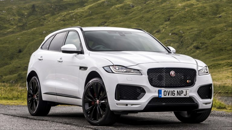 Jaguar F-Pace parked on a winding mountain road surrounded by green hills