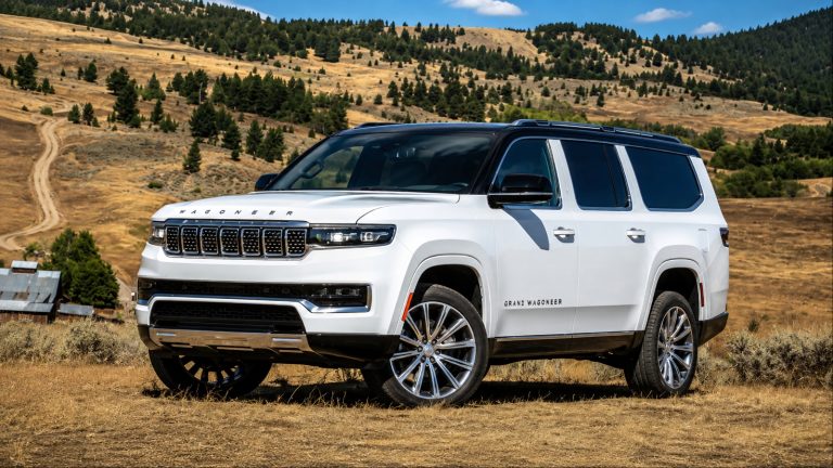 A white Jeep is standing in a hilly road