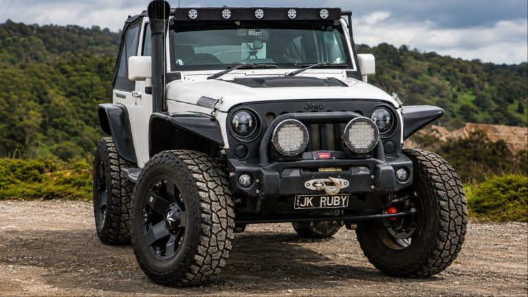 A Jeep Wrangler is standing with it's customized wheels