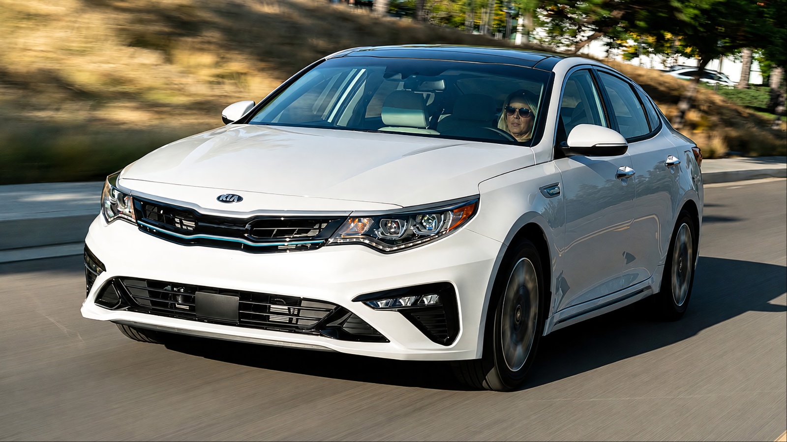 Kia Optima Hybrid driving on a suburban road