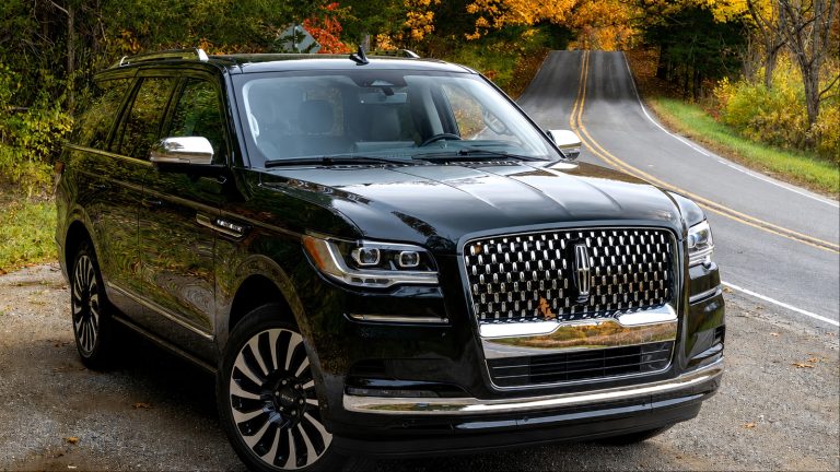 Lincoln Navigator parked on a scenic road surrounded by colorful autumn foliage
