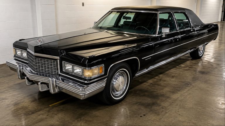 Black 1976 Cadillac Fleetwood Brougham stretch limousine parked indoors, glossy finish