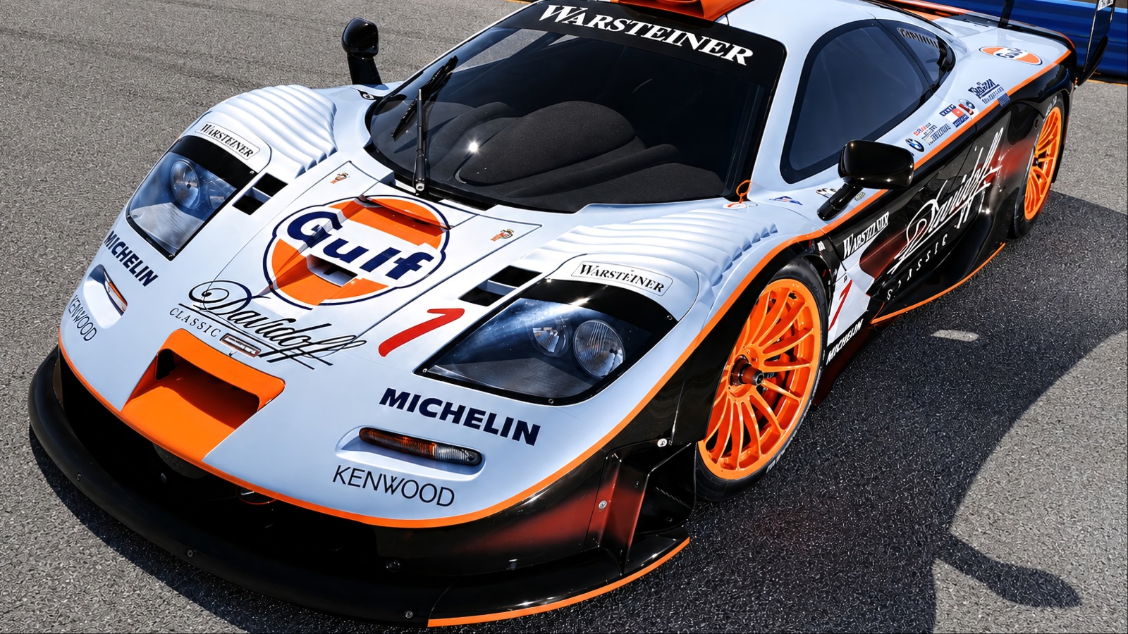 McLaren F1 GTR race car in Gulf livery, featuring a large rear wing and aerodynamic bodywork