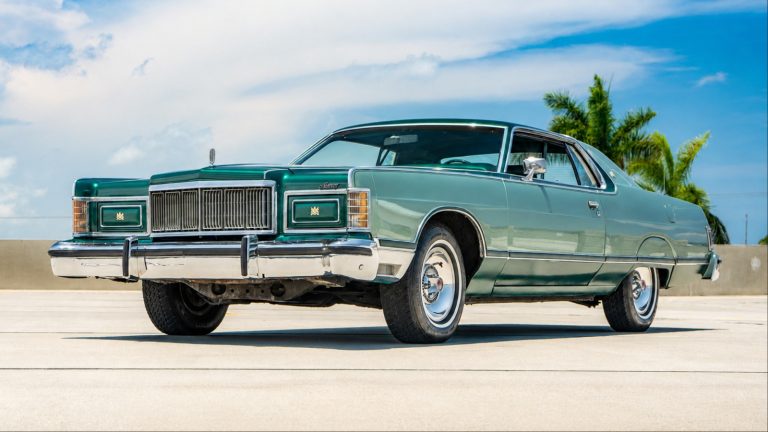 A Mercury Grand Marquis is standing on a flat road