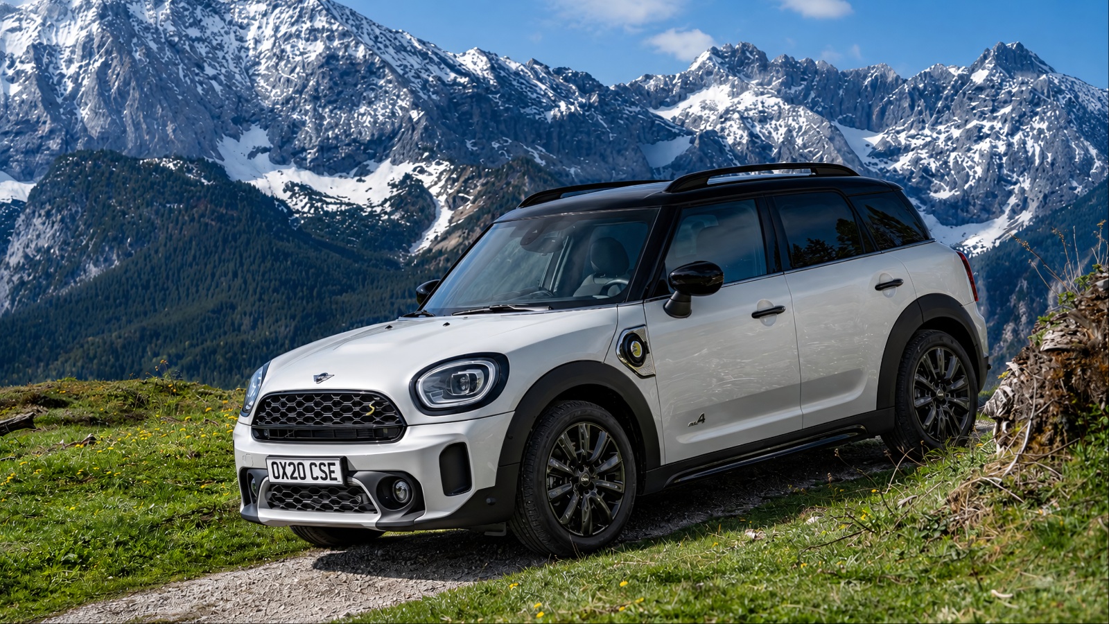 MINI Countryman Plug-In Hybrid parked on a mountain trail with snowy peaks behind it