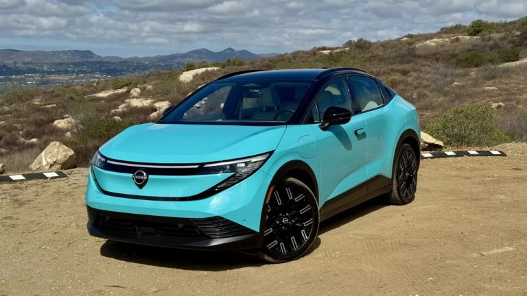 Nissan Leaf parked on a rugged hillside with scenic mountain views