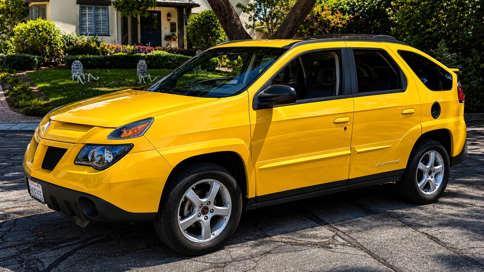 A yellow Pontiac Aztek is standing in a house parking
