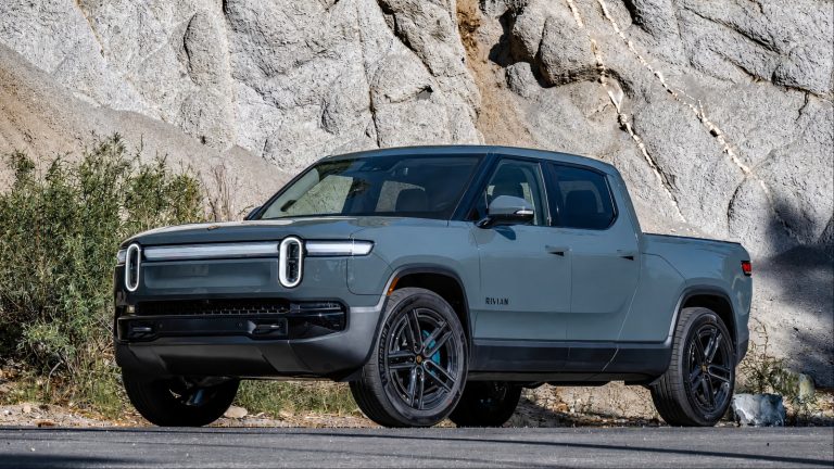 A Rivian R1T is standing beside a hilly terrain