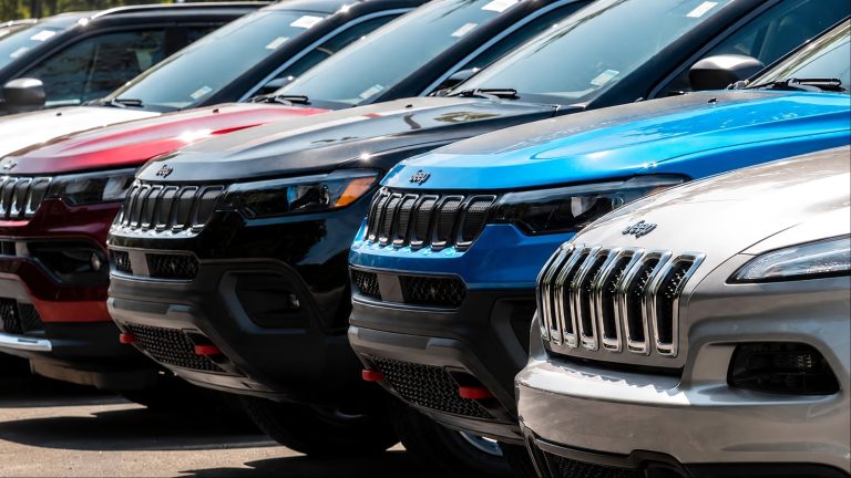 Row of new Jeep SUVs in various colors at dealership