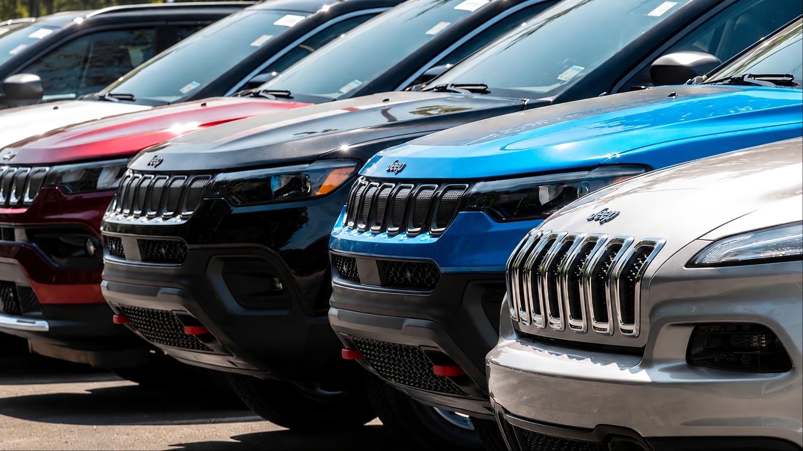 Row of new Jeep SUVs in various colors at dealership