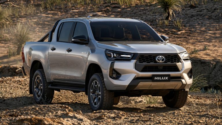 Toyota Hilux pickup truck parked on rugged terrain, showcasing its bold front design and off-road capability