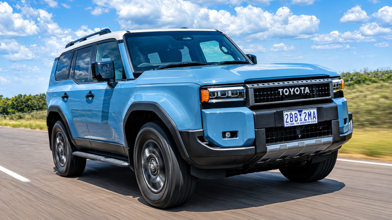 Toyota SUV driving on a highway with open countryside and blue skies