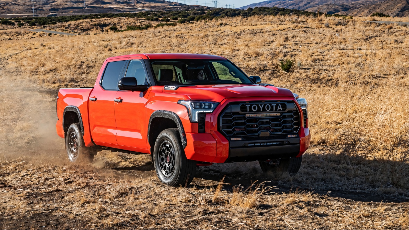 Toyota Tundra tackling rugged desert terrain with mountains in the background