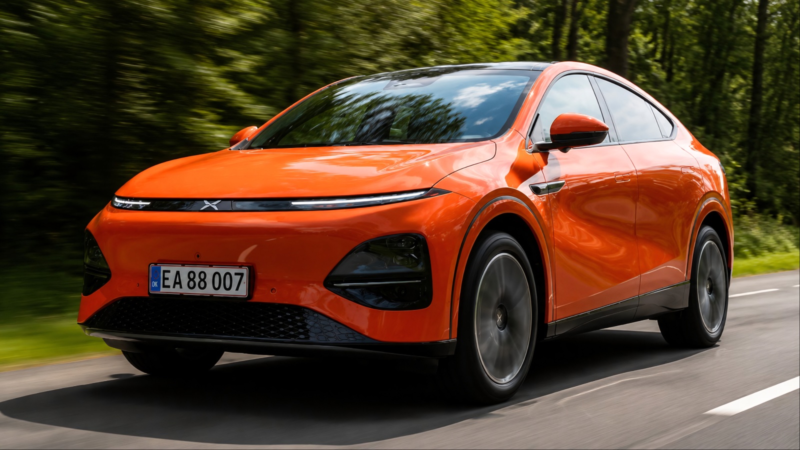 XPeng electric SUV driving on a forest road, highlighting its sleek modern design