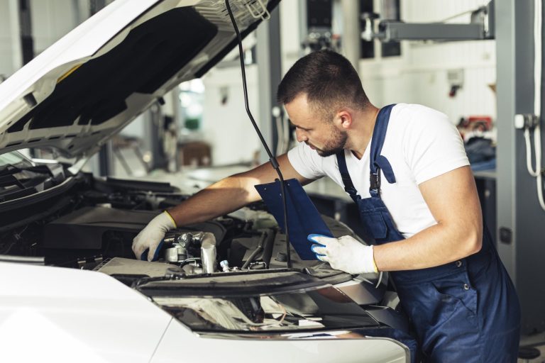 Mechanic inspecting vehicle powertrain