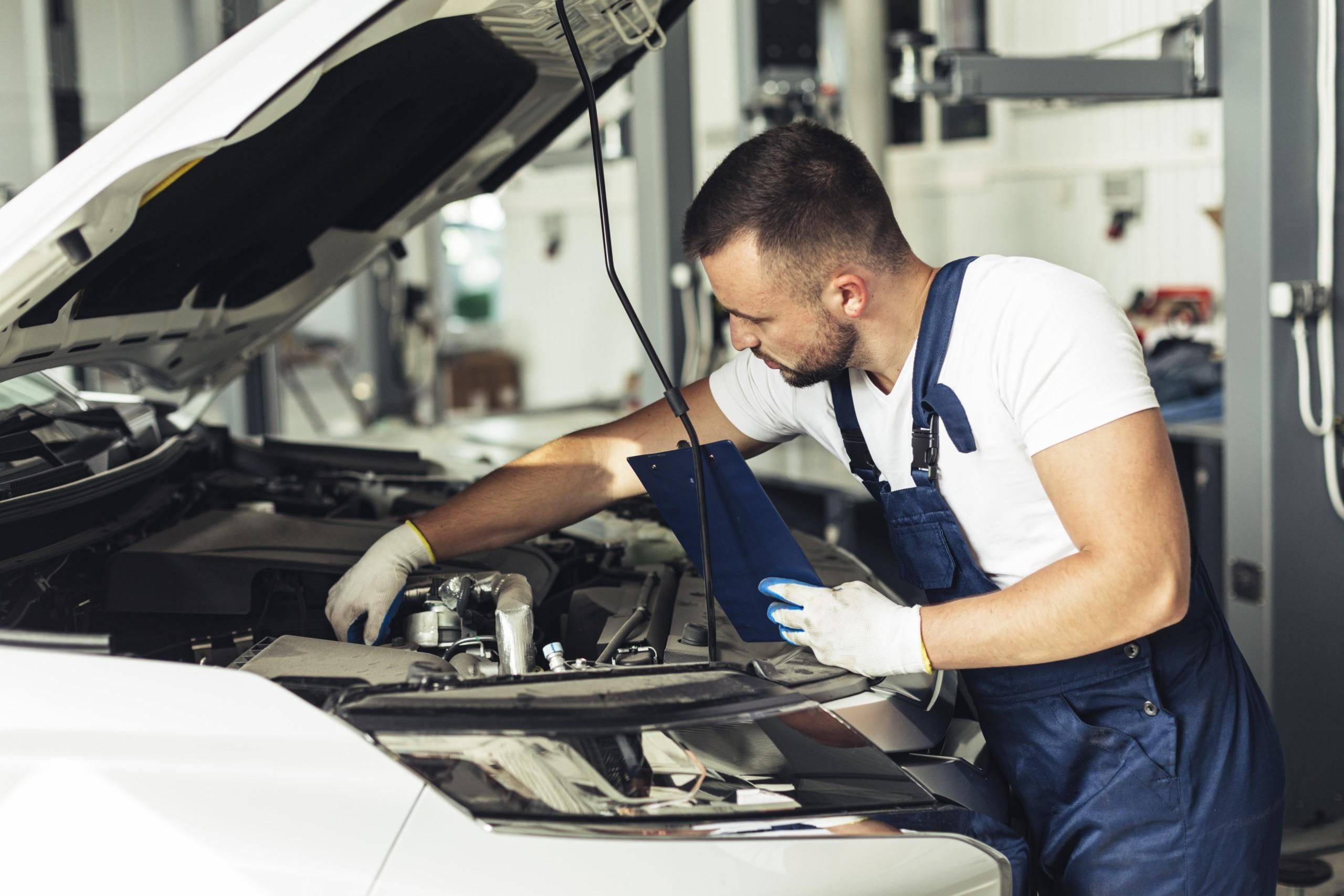 Mechanic inspecting vehicle powertrain